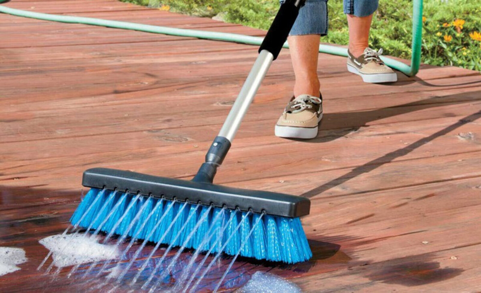 Professional pressure washing a concrete driveway using a surface cleaner to remove dirt, grime, and algae in Erie, PA.