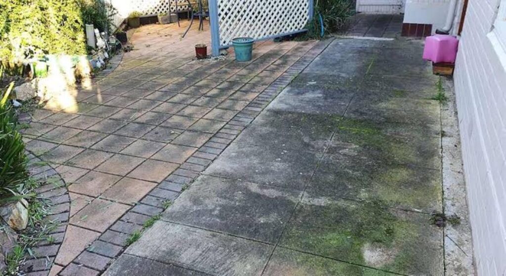 Dirty concrete driveway covered with dirt, algae, and surface stains before professional pressure washing.