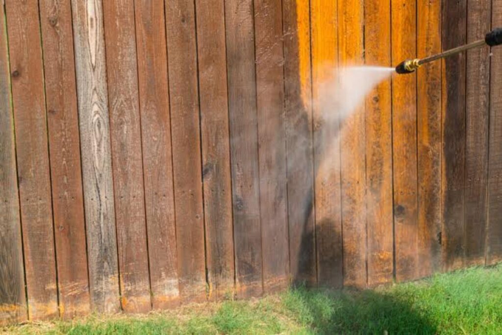 Summit Spray. Co Pressure completing a professional fence cleaning.